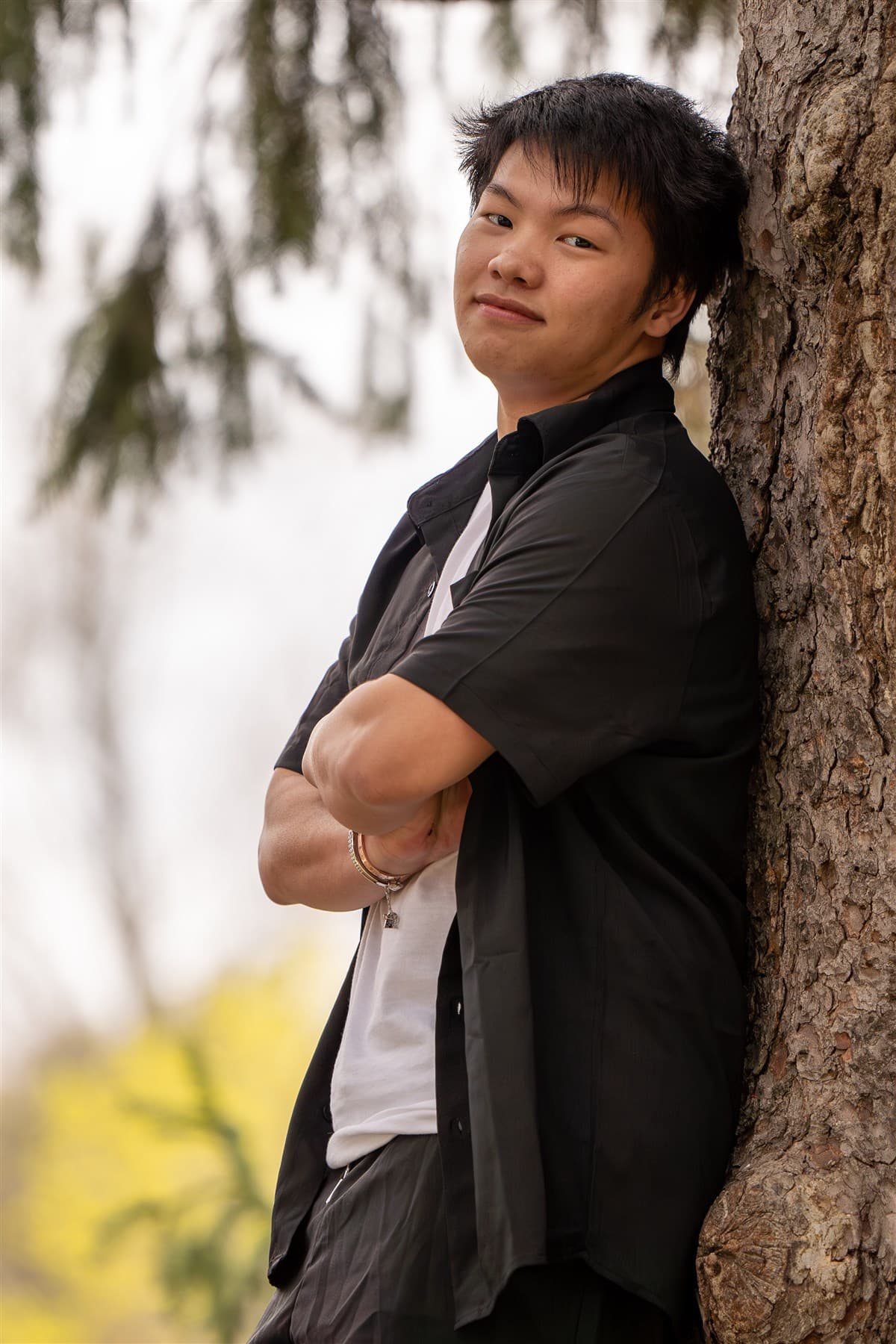 Outdoor portrait standing beside a tree line.