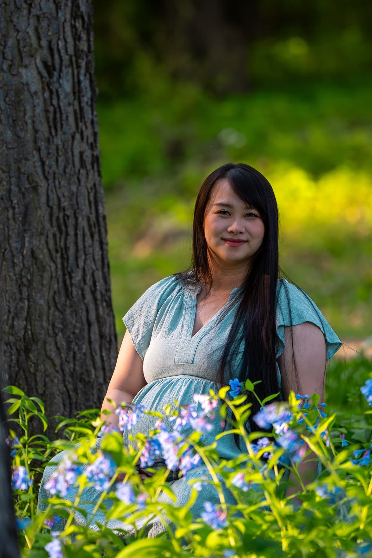 Portrait in a garden framed by flowers and greenery.