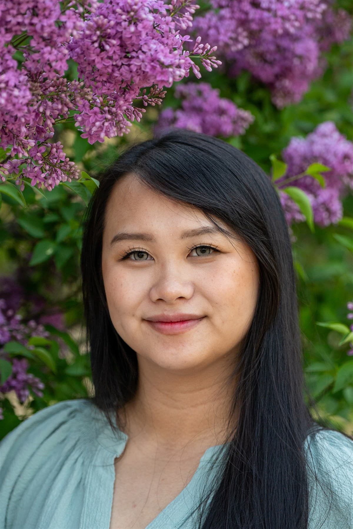 Close portrait in front of blooming lilacs.